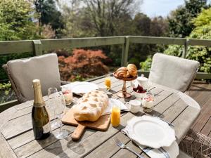 a wooden table with bread and a bottle of wine at Woolrich Historic Garden Accommodation in Olinda