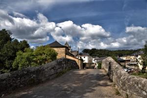 an old stone bridge over a road in a town at El Relax de Sanabria in Trefacio