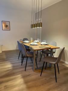 uma sala de jantar com uma mesa com cadeiras e um lustre em Ferienwohnung auf dem Sonnenhang em Bad Rothenfelde