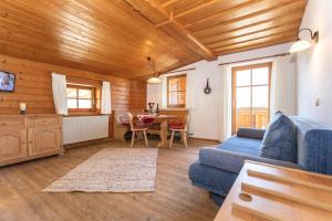 ein Wohnzimmer mit einem blauen Sofa und einem Tisch in der Unterkunft Haus Pfistererbauer in Brixen im Thale
