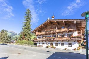 ein großes Holzgebäude mit Balkon auf einer Straße in der Unterkunft Haus Pfistererbauer in Brixen im Thale