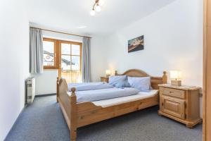 1 dormitorio con cama de madera y ventana en Haus Pfistererbauer, en Brixen im Thale