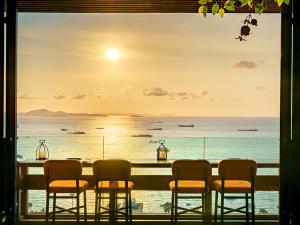 a table with chairs and a view of the ocean at Mytt Hotel Pattaya - SHA Extra Plus in Pattaya Central