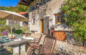 um pátio com uma mesa, cadeiras e um guarda-sol em Cottage Ginestre em Arola