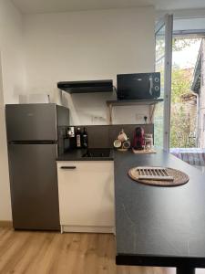 Il comprend une cuisine équipée d'un réfrigérateur et d'un comptoir. dans l'établissement Le Bjorn - T1 chaleureux refait à neuf - Centre, à Niort