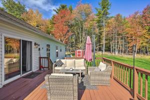 une terrasse avec des chaises et un parasol sur une maison dans l'établissement Game Room and Spacious Yard 10-Acre Catskills Home!, à East Durham