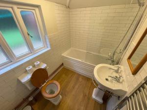 y baño con aseo, lavabo y bañera. en Historic 2 bed gatehouse in private parkland, en Brockenhurst