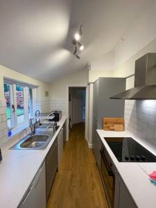 uma cozinha com um lavatório e uma bancada em Historic 2 bed gatehouse in private parkland em Brockenhurst