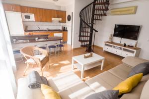 sala de estar con sofá y mesa en Home2Book Ático Blue Beach, Pool&Terrace, en Sardina