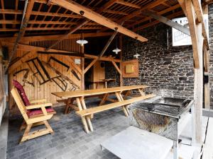 ロンドゥーにあるHoliday Home near the forestのレンガの壁の客室で、木製のテーブルと椅子が備わります。