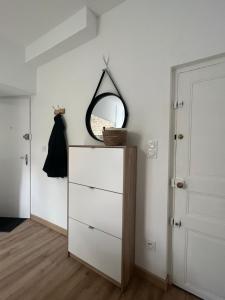 een slaapkamer met een dressoir en een spiegel aan de muur bij Le Bjorn - T1 chaleureux refait à neuf - Centre in Niort