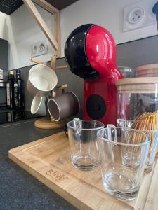 a red mixer sitting on top of a wooden cutting board at Le Bjorn - T1 chaleureux refait à neuf - Centre in Niort