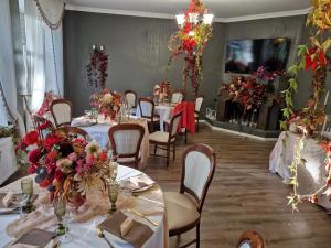 un comedor con mesas con flores. en Hotel Kārklu Muiža, en Jelgava