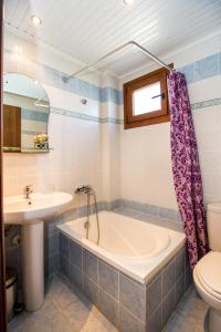 een badkamer met een bad, een wastafel en een toilet bij STUDIOS NIKOS in Limenaria