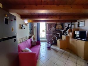 un soggiorno con divano rosa e scala di S.Giuseppe House a Pozzuoli