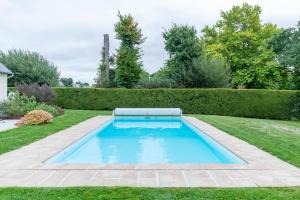 a swimming pool in the middle of a yard at Le Chemin Vert - maison avec piscine in Matignon