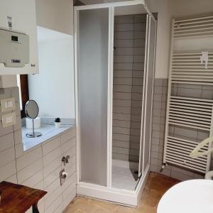 グッビオにあるAppartamenti Molino Settecaminiのバスルーム(ガラスドア付きのシャワー付)