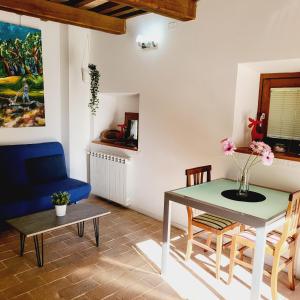 ein Wohnzimmer mit einem Tisch und einem blauen Stuhl in der Unterkunft Appartamenti Molino Settecamini in Gubbio