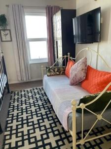um quarto com uma cama com almofadas em "The Quirky" Seafront Apartment em Eastbourne