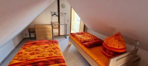 2 Betten in einem kleinen Zimmer mit Dachgeschoss in der Unterkunft Zollzeche Stadtwohnungen in Staßfurt