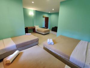een hotelkamer met 2 bedden en een bank bij Tekoma Resort Taman Negara in Kuala Tahan