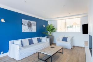 sala de estar con sofá blanco y pared azul en La Merveilleuse, en Kerlaz