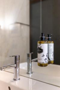 Un lavabo de baño con una botella de jabón encima en Tanger Suite - Foz, Serralves & beach, en Oporto