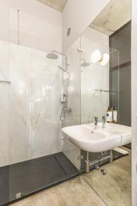 La salle de bains blanche est pourvue d'un lavabo et d'une douche. dans l'établissement Tanger Suite - Serralves, beach & Yayoi Kusama, à Porto