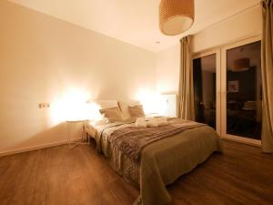 1 dormitorio con 1 cama con 2 lámparas en Zentral, modern, gemütlich mit Balkon & Parkplatz en Paderborn