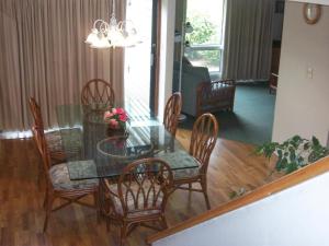 a dining room with a glass table and chairs at Sandcastle Village II in New Bern