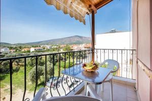 a table with a bowl of fruit on a balcony at STUDIOS NIKOS in Limenaria