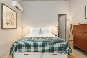 Schlafzimmer mit einem Bett mit einer schwarzen und weißen Decke in der Unterkunft Tanger Suite - Serralves, beach & Yayoi Kusama in Porto