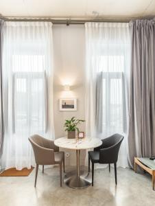 Tanger Suite - Serralves, beach & Yayoi Kusama في بورتو: طاولة وكراسي في غرفة بها نوافذ