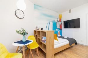 a bedroom with a bed and a desk and a tv at Kraków Trendy Studio Apartments by Renters in Krakow