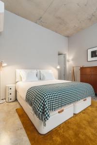 ein Schlafzimmer mit einem Bett mit einer schwarzen und weißen Decke in der Unterkunft Tanger Suite - Serralves, beach & Yayoi Kusama in Porto