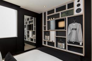 a room with a tv and a bed and a tv and a room with at Kip Hotel in London