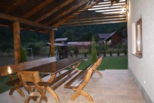 a wooden picnic table and benches on a patio at cabana din padure in Finiş