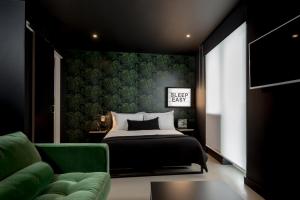 a bedroom with a bed and a green wall at Kip Hotel in London