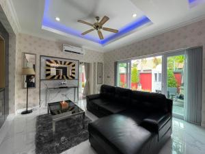 a living room with a black leather couch and a fireplace at VIEW TALAY VILLAs POOL 289, JOMTIEN BEACH, PATTAYA in Jomtien Beach