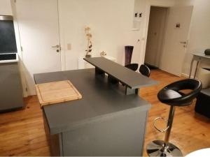 a kitchen with a desk and a chair in a room at The pop-art luxury suite in Charleroi