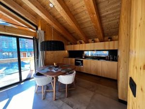 a wooden kitchen with a wooden table and chairs at Chalet One Jasná in Demanovska Dolina