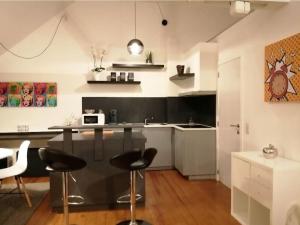 a kitchen with a counter and stools in a room at The pop-art luxury suite in Charleroi