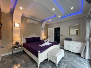 Un dormitorio con una cama morada con una flor blanca. en VIEW TALAY VILLAs POOL 289, JOMTIEN BEACH, PATTAYA en Jomtien Beach