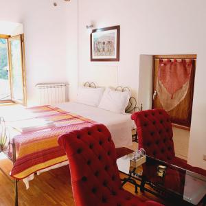 a bedroom with a bed and a red chair at Appartamenti Molino Settecamini in Gubbio