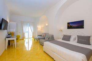 a hotel room with a bed and a couch at Relais Maresca Luxury Small Hotel & Terrace Restaurant in Capri