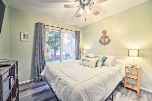 a bedroom with a bed with a ceiling fan and a window at Dog-Friendly Harrison Retreat with Grill and Fire Pit! in Harrison