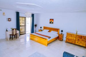 a bedroom with a wooden bed and a wooden dresser at Nature Kigali in Kigali