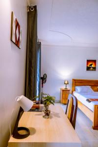Nature Kigali في كيغالي: غرفة نوم مع طاولة خشبية وسرير