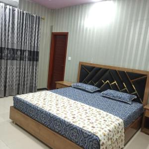 1 dormitorio con 1 cama con 2 almohadas en The Crown en Islamabad
