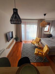een woonkamer met een bed en een tafel en stoelen bij Stan na dan Krsmanovic in Čačak